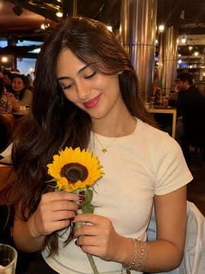 Woman with Sunflower in Warm Restaurant Setting preview