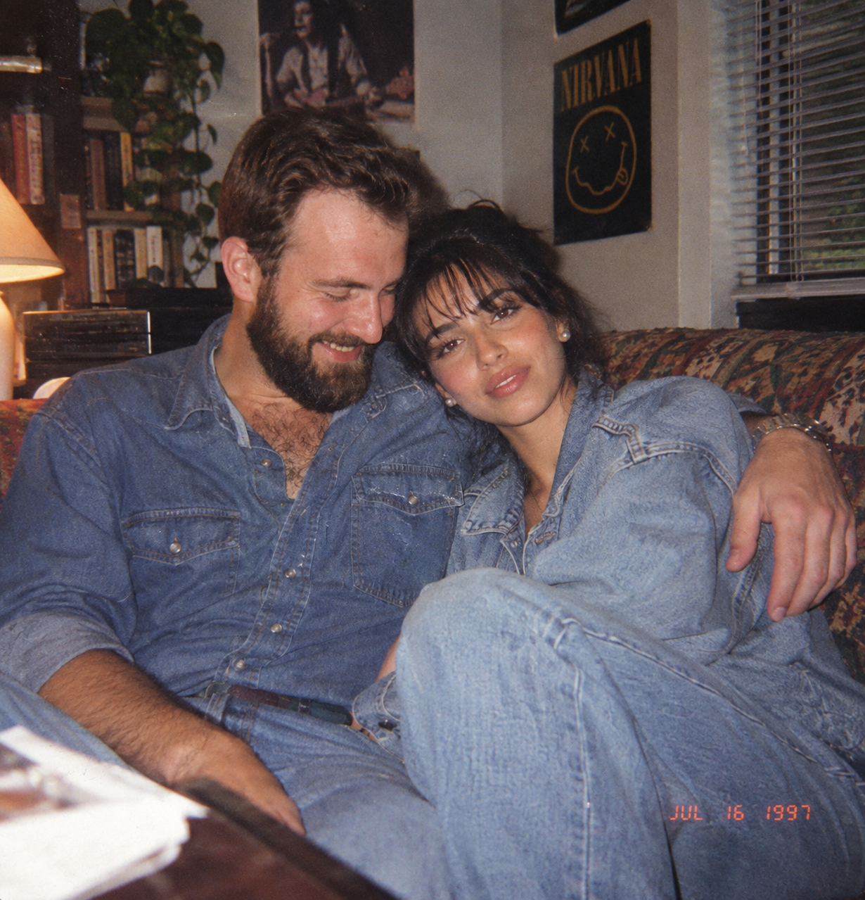 1990s couple photograph in casual denim with direct flash, 35mm grain and background clutter